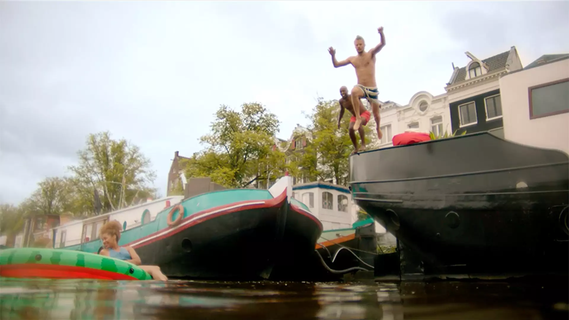 Homem pulando de um barco em um rio em Amsterdã